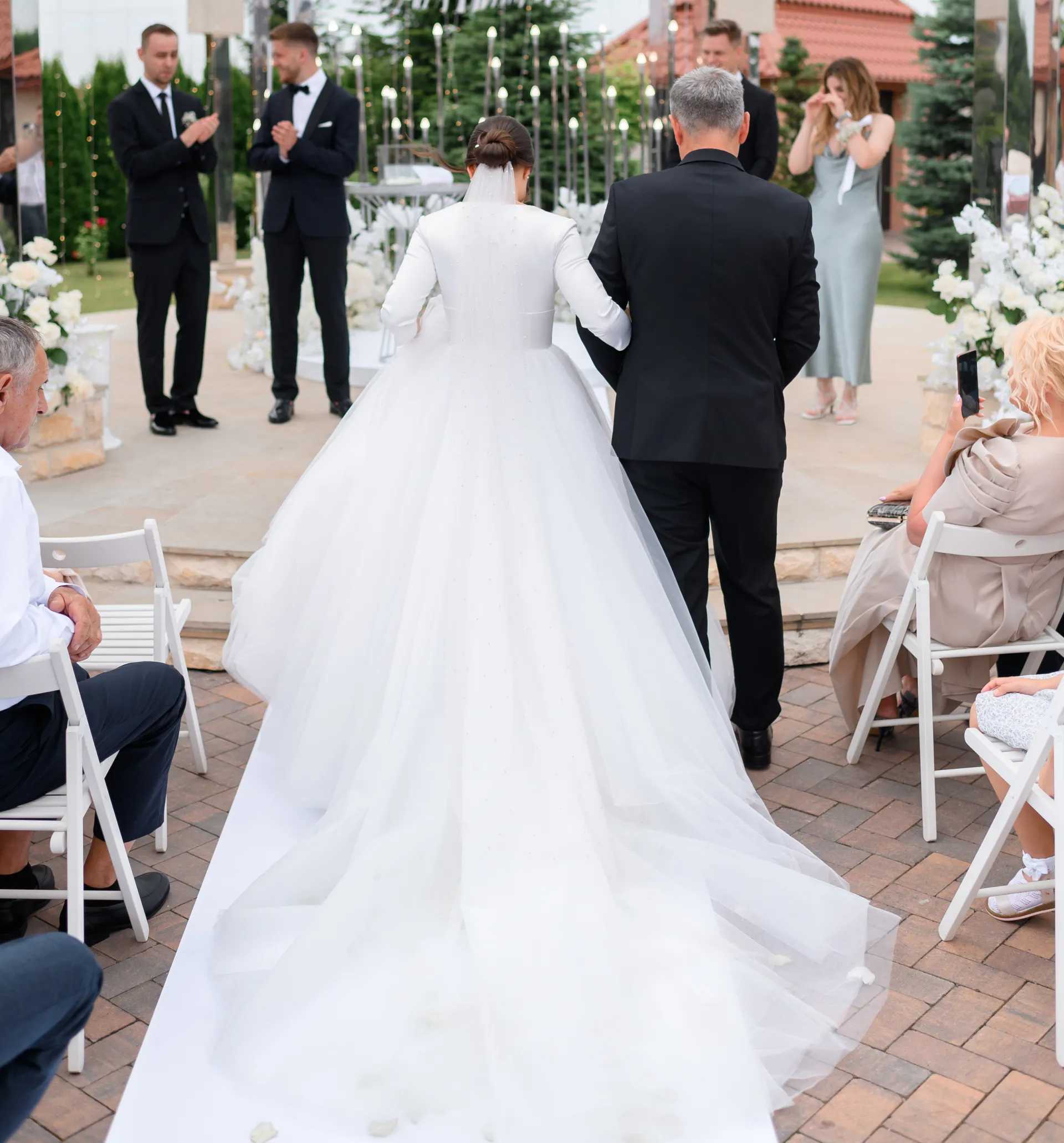 back-view-loving-father-with-bride-daughter-long-puffy-white-dress-go-goom-wedding-ceremony-outdoors-touching-moment-guests-married-couple-stylish-wedding-altar